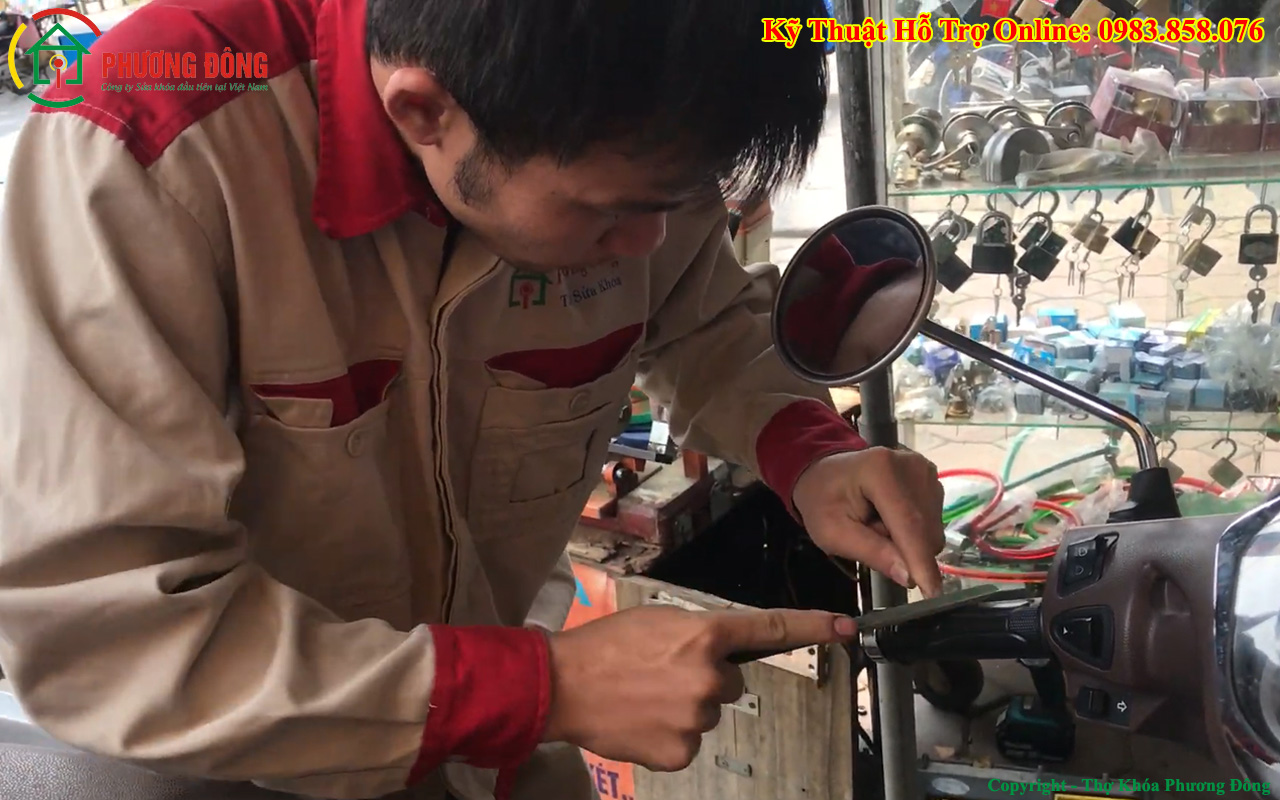 thợ đang sửa khóa xe máy